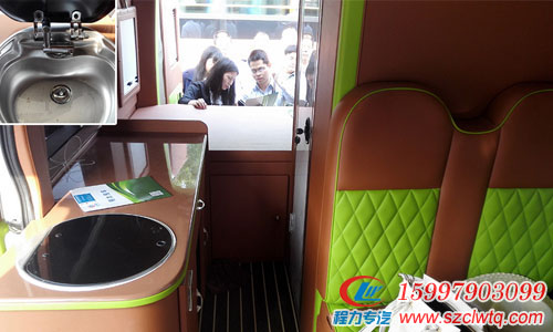  我們現(xiàn)在向后轉(zhuǎn)，可以看到后車廂的全貌，沙發(fā)后面是衛(wèi)生間，車身內(nèi)的右側(cè)是 一個料理臺和儲物柜，中間固定了一個50升的美固車載冰箱，洗手池配有折疊式 水龍水，不用的時候可以折疊收起，蓋上蓋子，上面還可以放一些雜物，再后面 就是后置固定雙人床了，受制于車內(nèi)尺寸，床尺寸為1810*1100mm.
